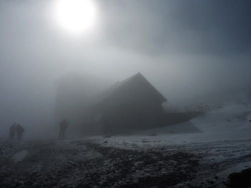Berghütte im Nebel und Sonne